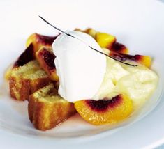 a white plate topped with bread and fruit covered in whipped cream on top of it