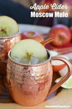 two copper mugs filled with apple cider moscow mule