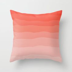 an orange and pink ombreed pillow on a white wall with a black frame