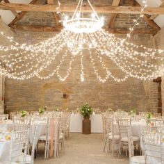 an indoor wedding venue with chandeliers and tables