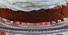 a cake with white frosting sitting on top of a glass plate