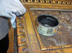 an old wooden table with some paint on it and a white glove next to it