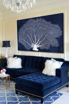 a living room with blue couches and white pillows