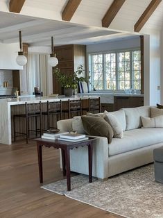 a living room filled with furniture next to a kitchen