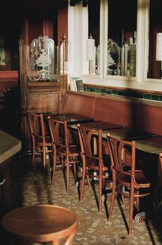 a row of wooden chairs sitting next to each other in front of a counter top