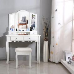 a white dressing table with mirror and stool