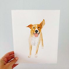 a hand holding up a small card with a dog on it's face and tongue sticking out