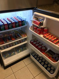 an open refrigerator filled with lots of sodas and cans on the shelves next to each other