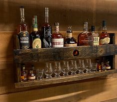 a wooden shelf filled with lots of bottles and glasses