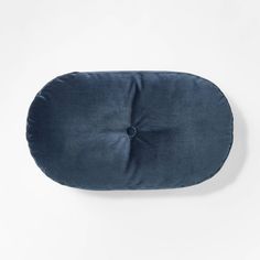 a blue round pillow sitting on top of a white wall