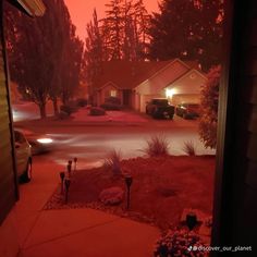 a house is shown at night with the lights on and cars parked in the driveway