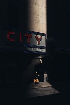 the city sign is lit up in the dark, and it appears to be empty