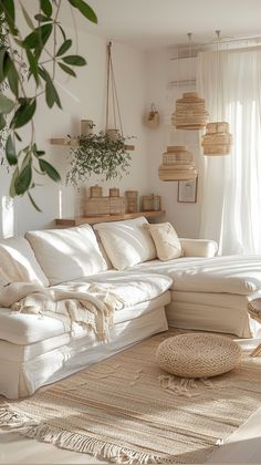 a living room filled with lots of white furniture and pillows on top of a rug