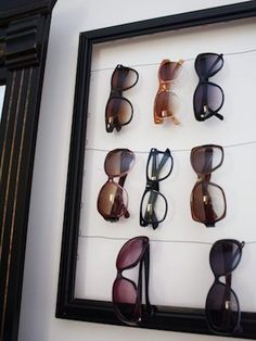 there are many pairs of sunglasses on display in the frame with glasses attached to it