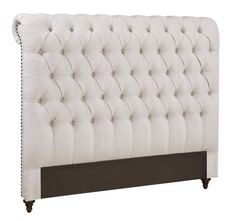 an upholstered headboard with buttons and nailing on the top, in white linen