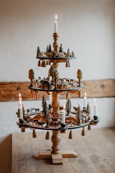 a wooden table topped with a christmas tree made out of candles and figurines