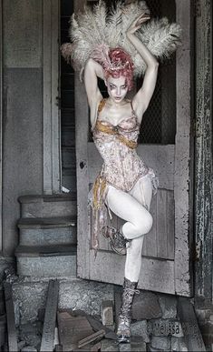 a woman with red hair and white makeup is posing in front of an open door