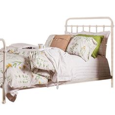 a white metal bed frame with pillows and blankets on it, against a white background