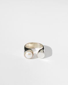 This split band makes a striking, sculptural statement. Cast in solid brass or sterling silver and set with a glowing white pearl. Band measures 8 mm wide, pearl measure 9mm in diameter. Available in sizes 4-12. Availablility: Made to order, ships in 2-4 weeks. Need it sooner? Please don't hesitate to get in touch and we'll do our best to accommodate. Libra Ring, Caged Sandals, Black Tank Dress, Black Aviators, Neon Purple, Silver Pearls, Earring Necklace, Pearl White, Solid Brass