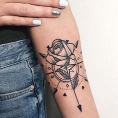 a woman's arm with a rose and arrow tattoo on the left side of her arm