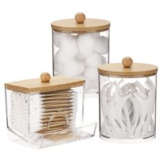 two clear containers with wooden lids and white balls in them