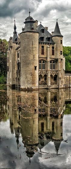 an old castle is reflected in the water