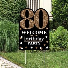 a black and gold 70th birthday party welcome sign in front of a house with greenery