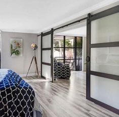 a bedroom with hardwood floors and sliding glass doors