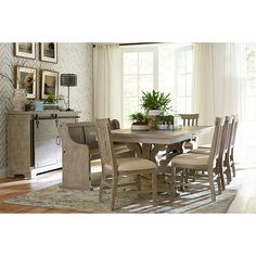 a dining room table with chairs and a potted plant on top of the table