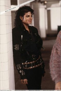 michael jackson as michael jackson in the movie michael jackson is shown standing next to a column