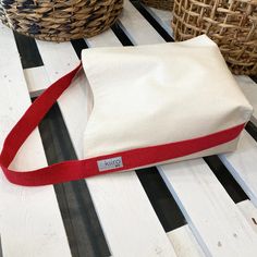 a white and red bag sitting on top of a table next to wicker baskets