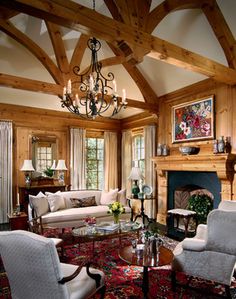 a living room filled with lots of furniture and a chandelier hanging from the ceiling