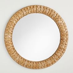 a round mirror that is made out of wicker