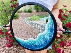 a person holding a magnifying glass with an image of a wave