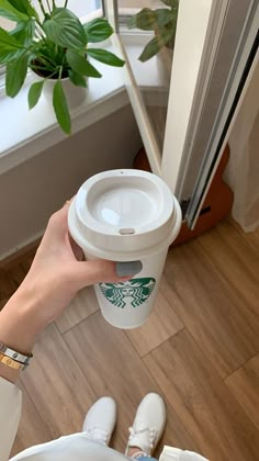 a person holding a starbucks cup in their hand