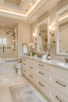 a large bathroom with white cabinets and marble counter tops