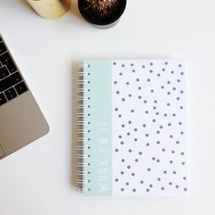 a notebook sitting on top of a desk next to a laptop