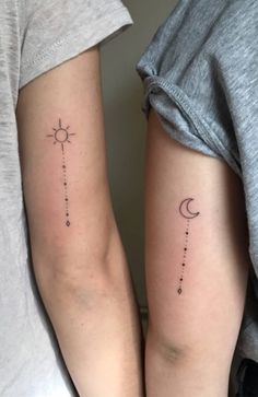 two people with matching tattoos on their arms, one is holding the other's arm