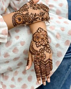 a woman's hand with henna tattoos on it