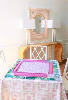 a pink and white table with a mirror on it