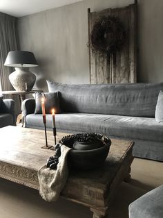 a living room filled with furniture and a lit candle on top of a coffee table