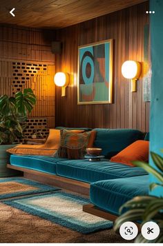 a living room filled with blue couches next to a wooden wall and potted plants