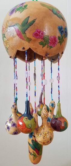 a wind chime hanging from the ceiling with flowers painted on it's sides