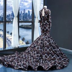 a mannequin dressed in a black and white dress with cityscape behind it