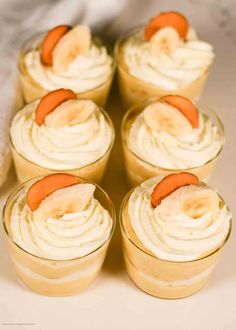 small desserts with banana slices and whipped cream in glass bowls on a tablecloth