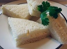 four pieces of bread with parsley on top sit on a plate, ready to be eaten