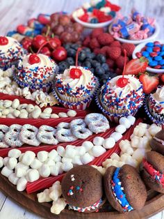 an american flag dessert platter with cupcakes, cookies and berries