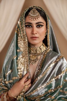 a woman in a green and gold bridal outfit