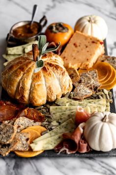 an assortment of cheeses, crackers and other food items on a platter