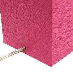 a pink square object with two small sticks sticking out of it's center hole